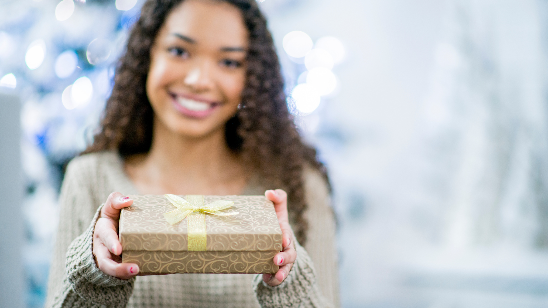young woman offering gift for therapist in a holiday setting
